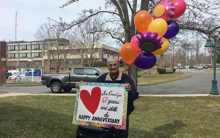 Husband Holds Sign For Wife Outside Nursing Home On 67th Anniversary After They Ban Visitors