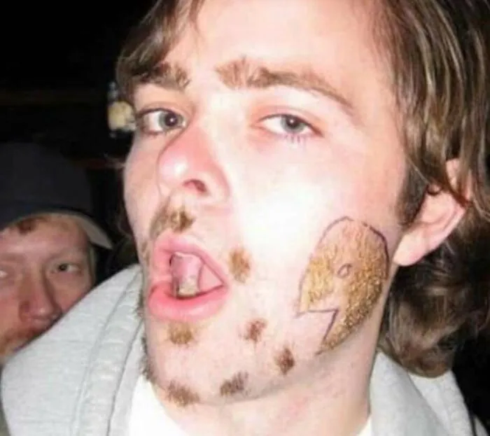Man with unique beard design and playful expression, showcasing worst hairstyle trends.