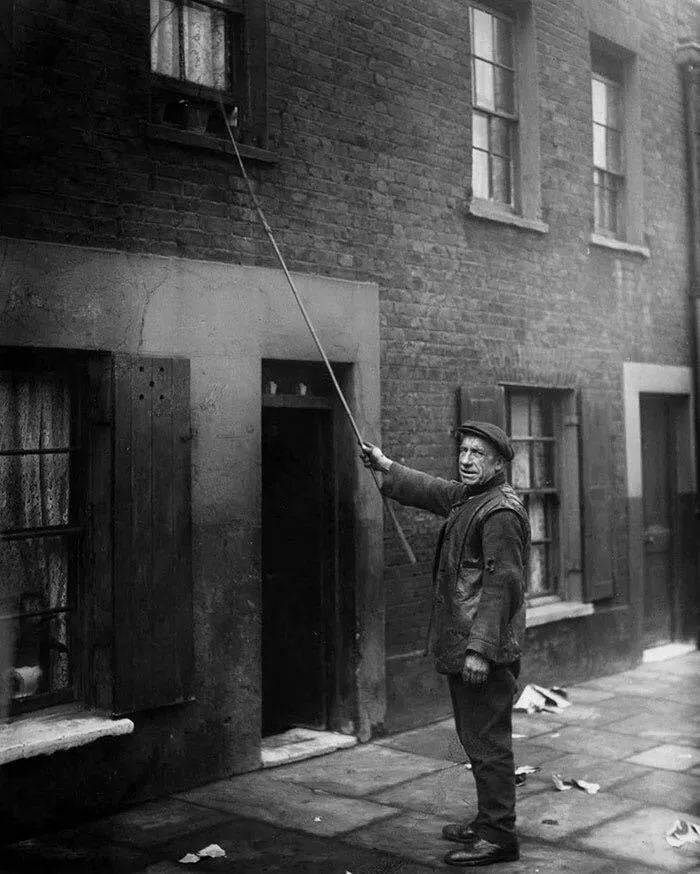 Un despertador en Londres (1929). Antes de las alarmas, despertar a las personas para que fueran a trabajar era un trabajo remunerado. Los “despertadores” golpeaban las puertas y ventanas con un palo