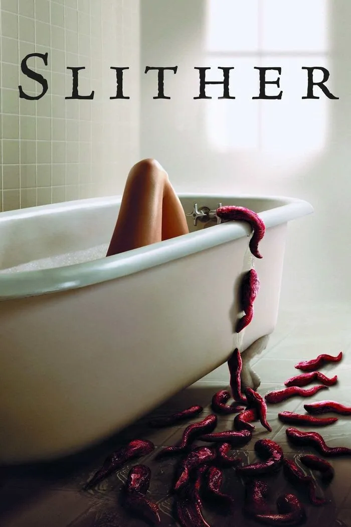 Person in bathtub with red slithering creatures spilling over the side, a scene from a horror comedy movie.