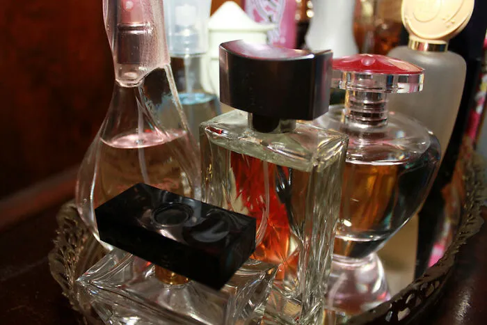 A Bottle Of Perfume And A Pair Of Scissors