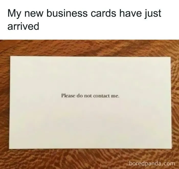 Introvert Nation meme showing a business card with text please do not contact me on a wooden surface.
