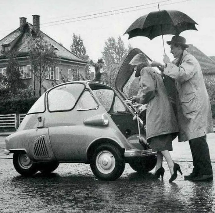 Una pareja entra en su Bmw Isetta, por la puerta principal, 1950