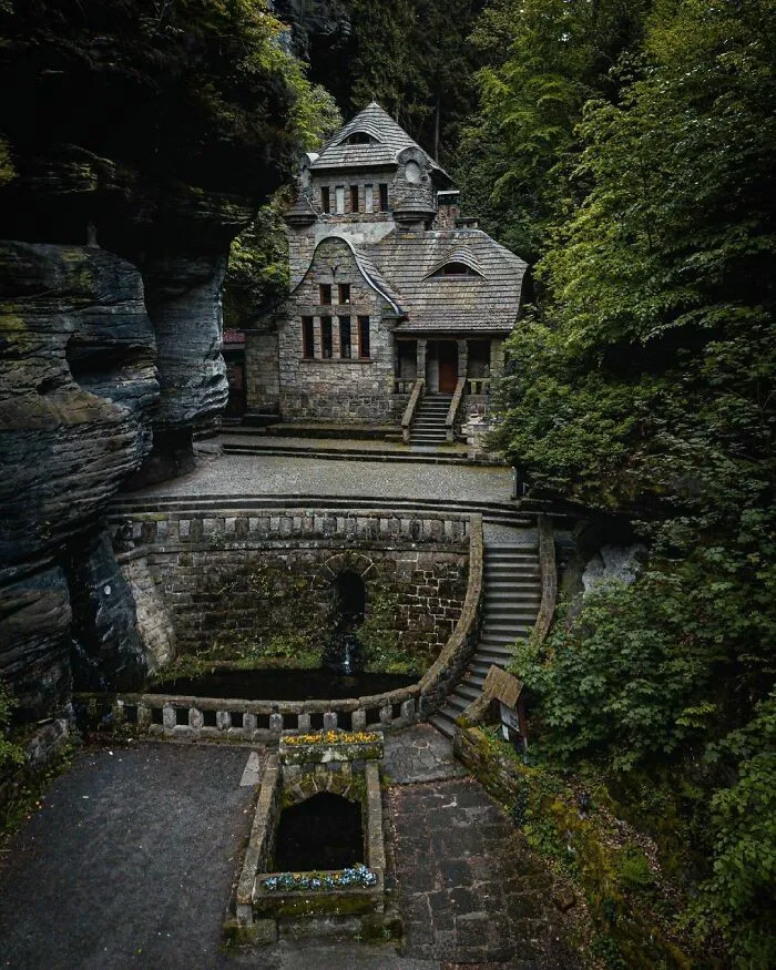 A Beautiful House Surrounded By Rock And Trees In Hrensko