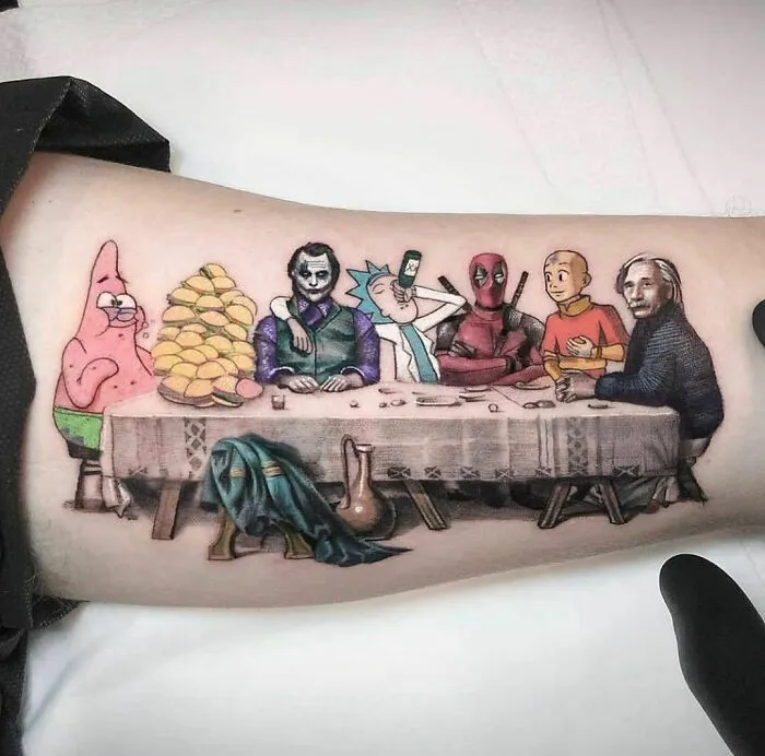 Crazy tattoo featuring cartoon and comic characters inspired by "The Last Supper" on an arm.