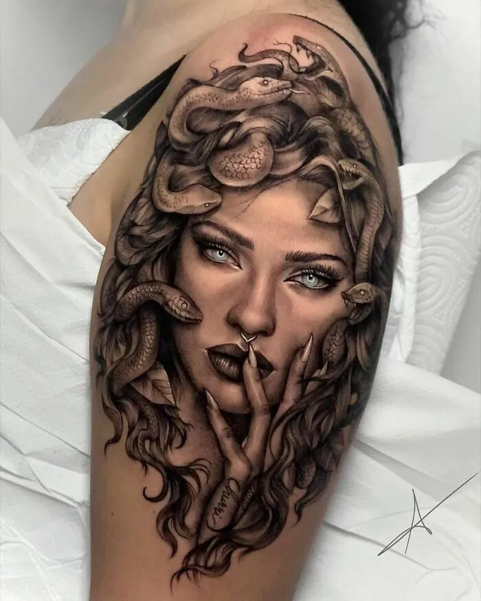 Tattoo of a woman's face with snakes on an arm, showcasing unique and crazy ink designs.