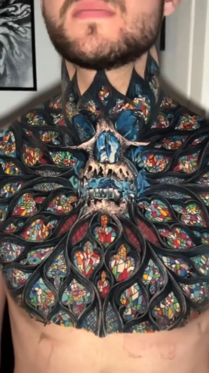 Intricate stained glass tattoo design on a person's chest, showcasing unique and colorful art.