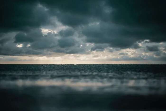 Dark stormy ocean horizon under heavy clouds, illustrating creepy facts about the ocean and its mysterious depths.