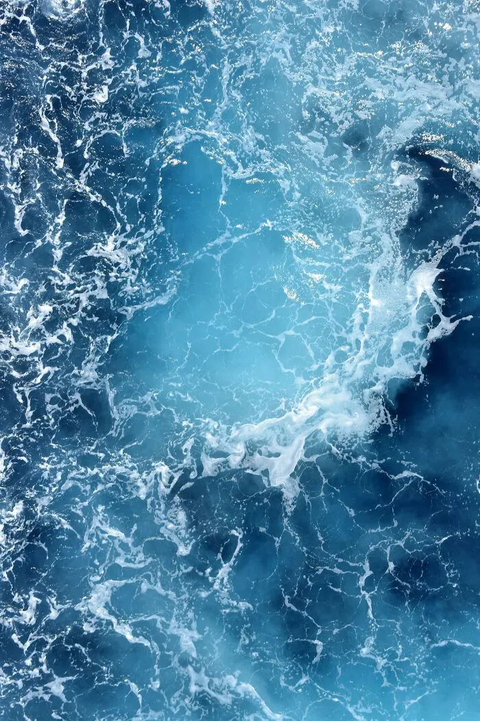 Turbulent ocean water with frothy white waves and deep blue hues showcasing creepy ocean facts visually.