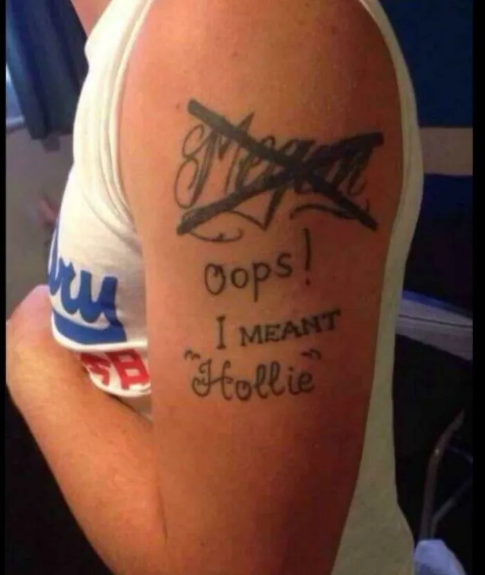 Tattoo with a crossed-out name, showcasing one of the “worst tattoos,” reads “Oops! I meant Hollie” on a person's arm.