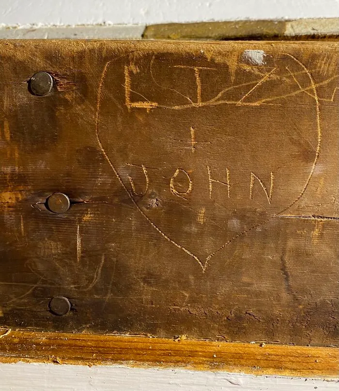 Bottle Of Vodka Tucked In The Insulation And Names Of Previous Owners Carved In Beam