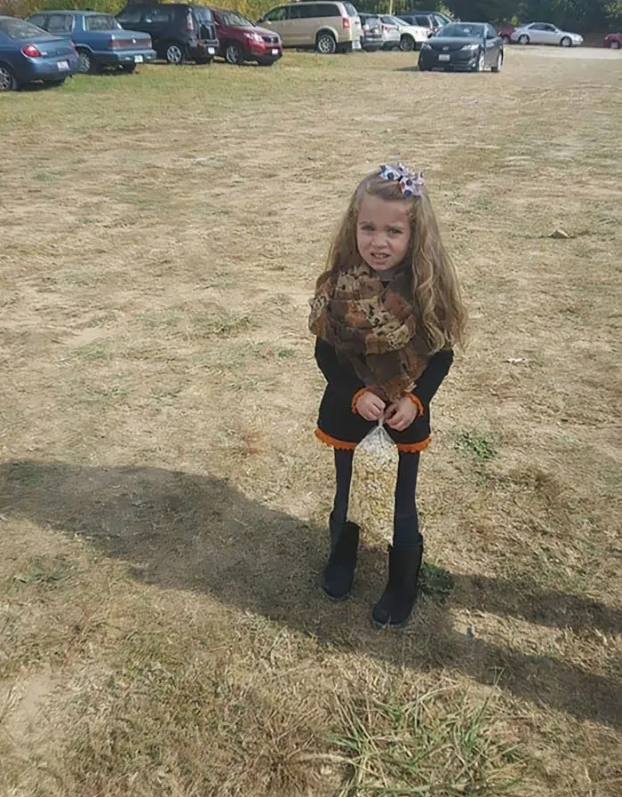 Una niña posando con una bolsa de palomitas