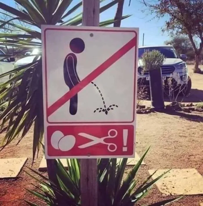 Funny no urinating sign with a warning illustration on a sunny day.