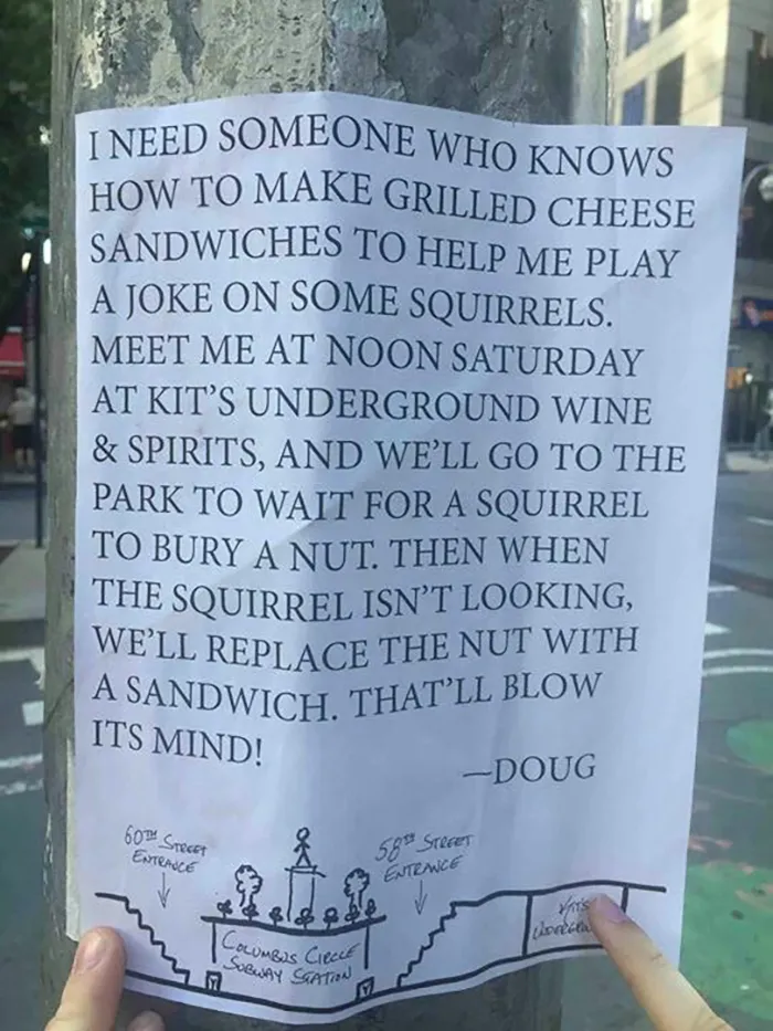 Funny sign taped to a pole about playing a joke on squirrels with grilled cheese sandwiches.