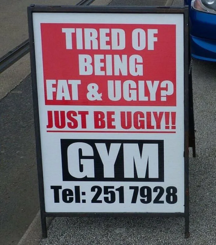 Funny sign outside gym with bold text: "Tired of being fat & ugly? Just be ugly!!"