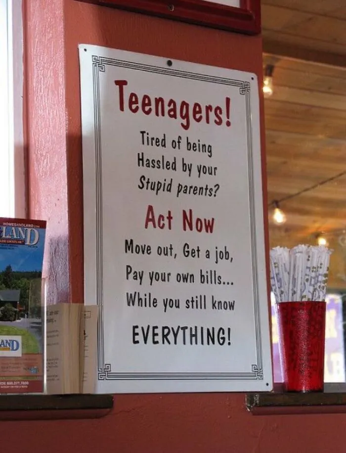 Funny sign with witty advice for teenagers about moving out, getting a job, and paying bills.