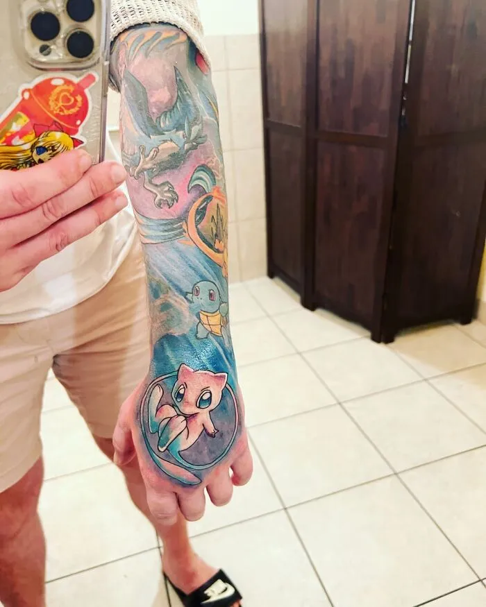 Colorful tattoo sleeve featuring various Pokémon characters on a person's forearm.