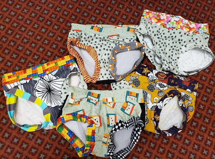 Assorted colorful underwear on patterned carpet, featuring bizarre and unlikely designs.