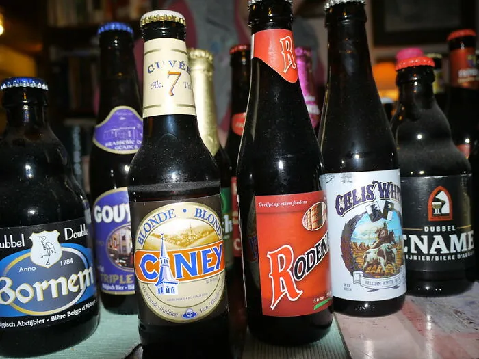 Various Belgian beer bottles displayed on a table.