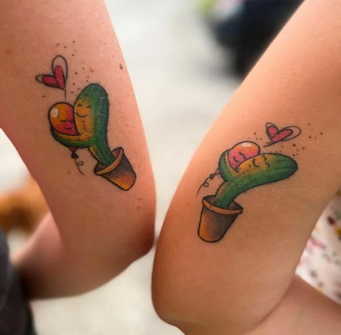 Two matching cactus tattoos with hearts symbolize friendship on arms.