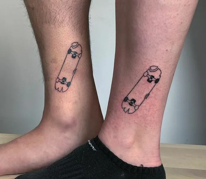 Matching skateboard tattoos on two ankles symbolizing best friend connection.