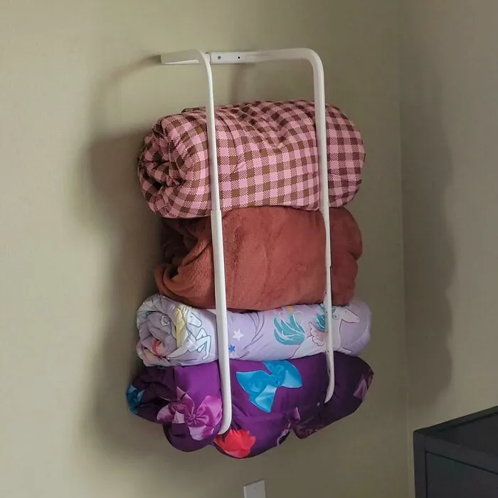 IKEA hack: White frame used creatively as a wall-mounted storage for folded blankets.