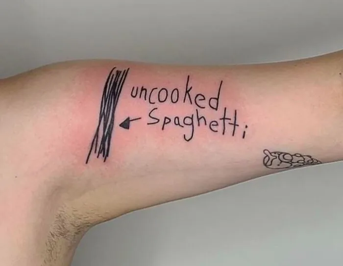 Tattoo of uncooked spaghetti sketch with text on an arm, showcasing creative word tattoos.