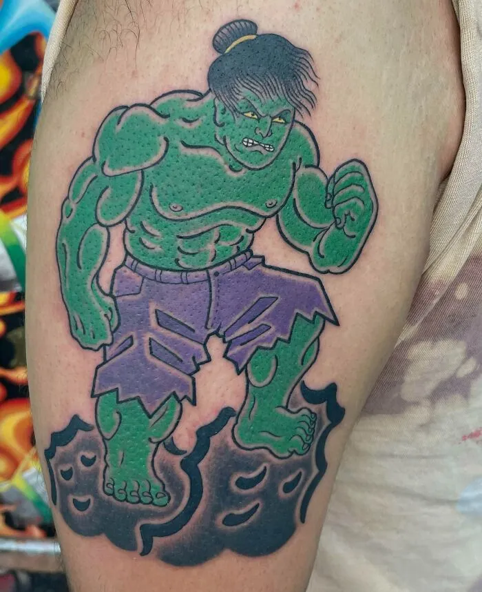Hulk tattoo with green skin and purple pants, representing a Marvel character on someone's arm.