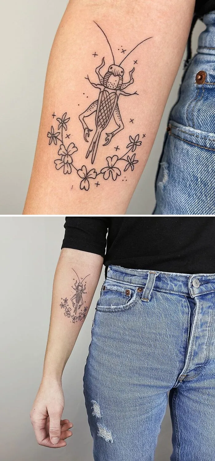 Animal tattoo of an insect with floral accents on a person's arm, wearing denim jeans.