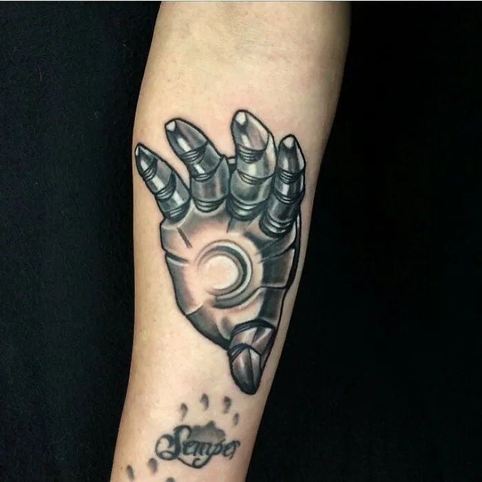 Marvel tattoo of Iron Man's hand on forearm, showcasing detailed artwork reflecting superhero theme.