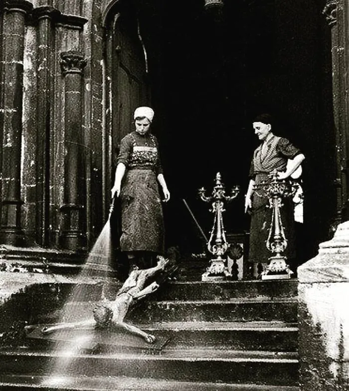 Woman washing a statue with water 