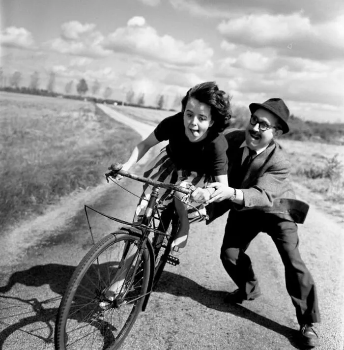 Man teaching a small kid how to ride a bike 