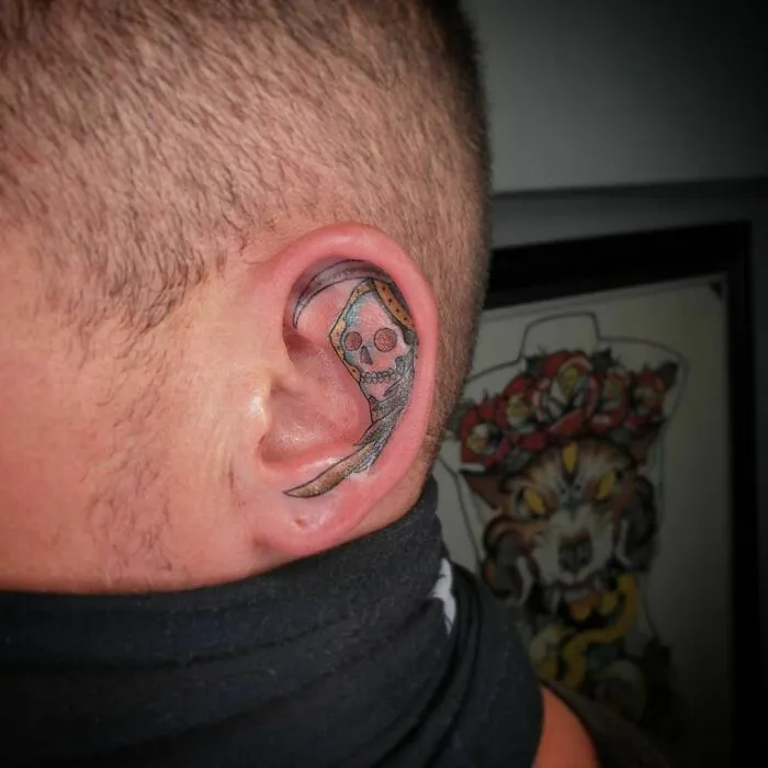 Skull-themed ear tattoo with bold colors and intricate details.
