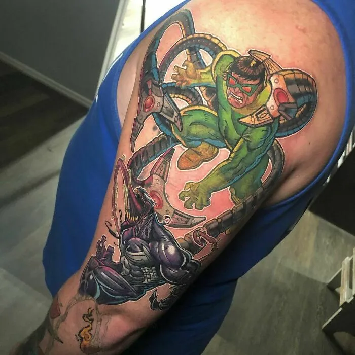 Marvel tattoo featuring characters battling, showcasing vibrant colors and dynamic design on a person's arm.