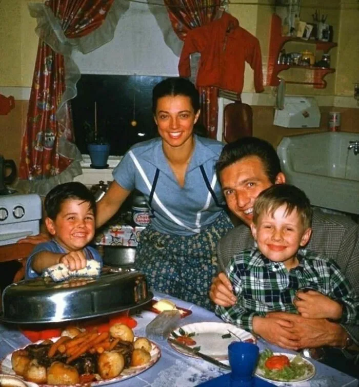 Happy family of four sitting at the dinner table 