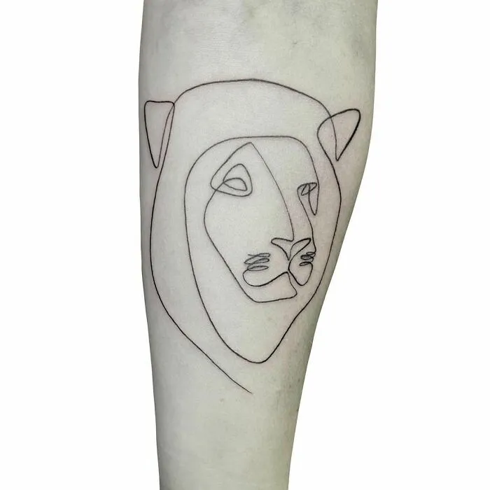 Single-line tattoo of a lion's face, showcasing fine-line perfection on an arm.