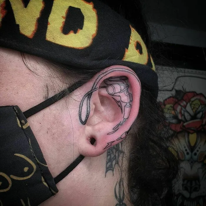 Ear tattoo featuring intricate black linework and abstract design.