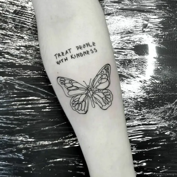 Butterfly and quote tattoo on forearm for creative word tattoo inspiration.