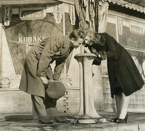A Couple Drinking Water From Fountain. Michigan, 1940s