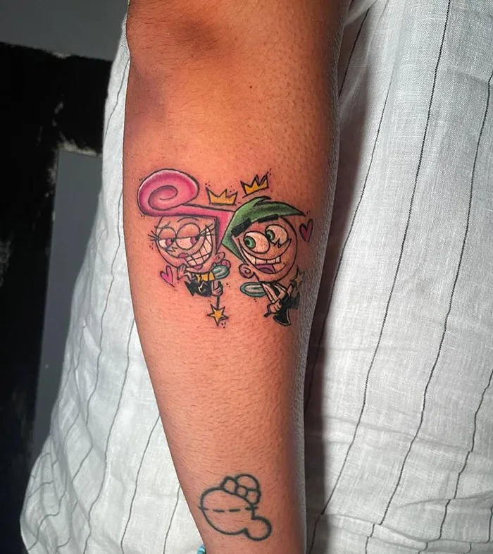 Cartoon tattoo on arm featuring colorful characters from an animated show, showcasing creative tattoo art.