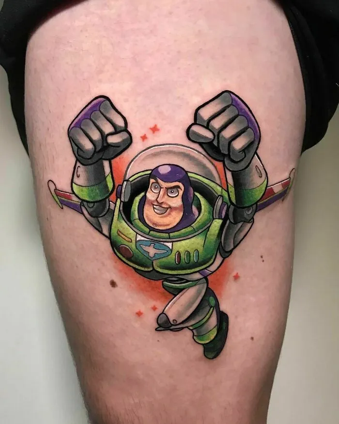 Cartoon tattoo of a space ranger character from an animated show, featuring vibrant colors on a person's thigh.