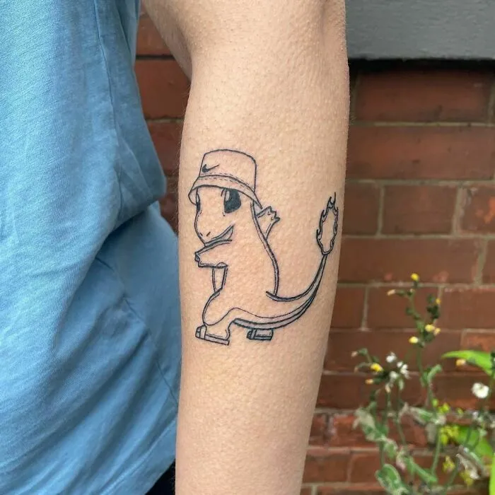 Cartoon tattoo of a character wearing a hat and sneakers on an arm, inspired by animated shows.