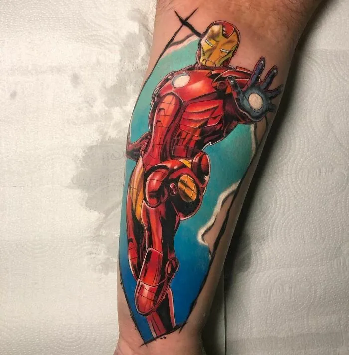 Vibrant tattoo of Iron Man on arm, showcasing Marvel artistry with dynamic colors.