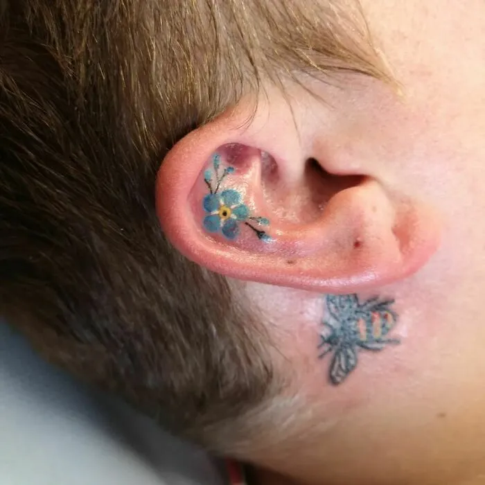 Flower and bee ear tattoos, showcasing creative ear tattoo ideas.