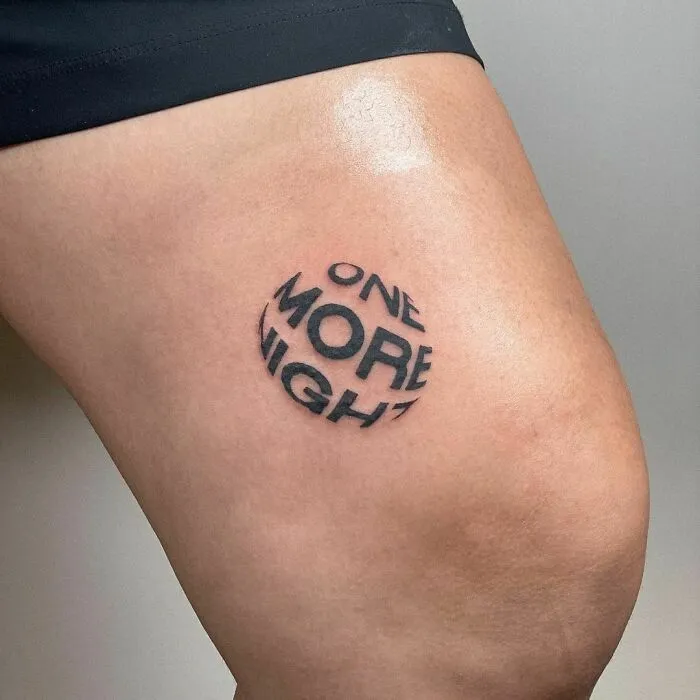 Tattoo of the words "One More Night" on a person's leg, showcasing word tattoos.