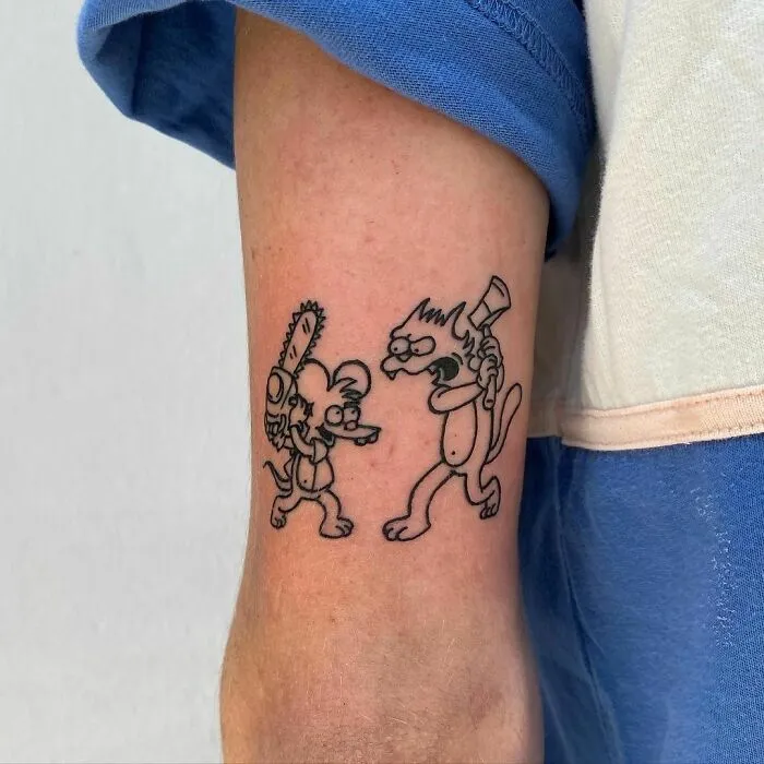 Cartoon tattoo of a rat and cat fighting, inspired by The Simpsons, on a person's arm.