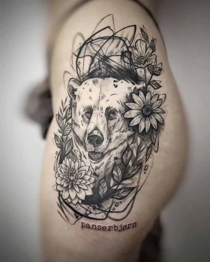 Realistic bear tattoo with floral accents on the arm, highlighting animal tattoo simplicity and realism.