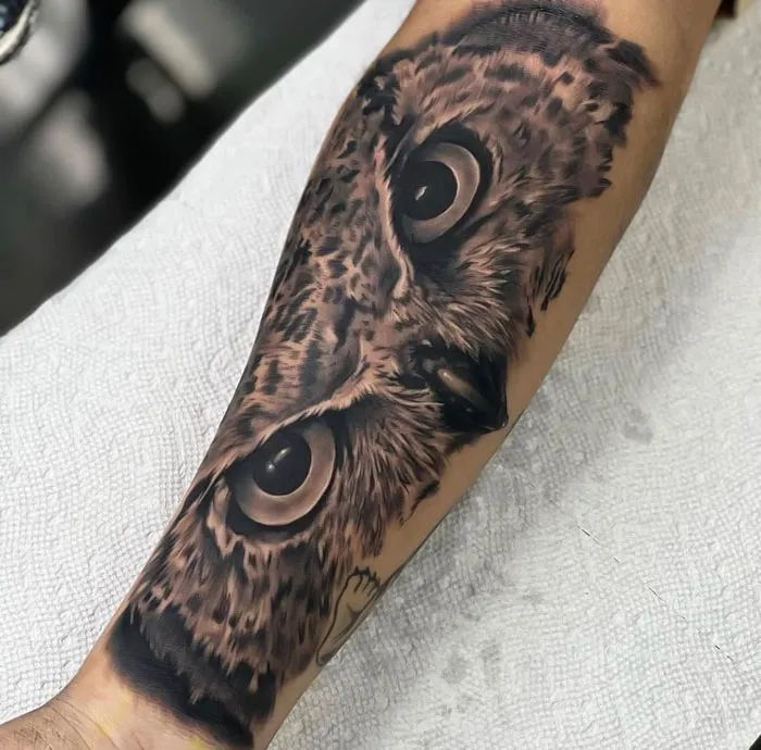 Realistic owl tattoo design on a forearm, showcasing intricate detail and simplicity in animal art.