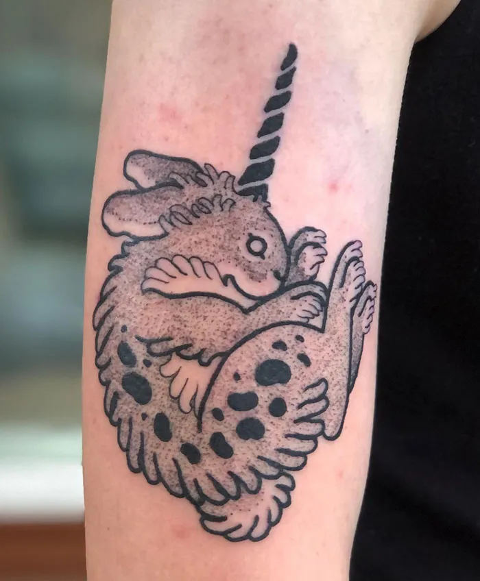 Animal tattoo featuring a mythical jackalope with a detailed black ink design on the arm.