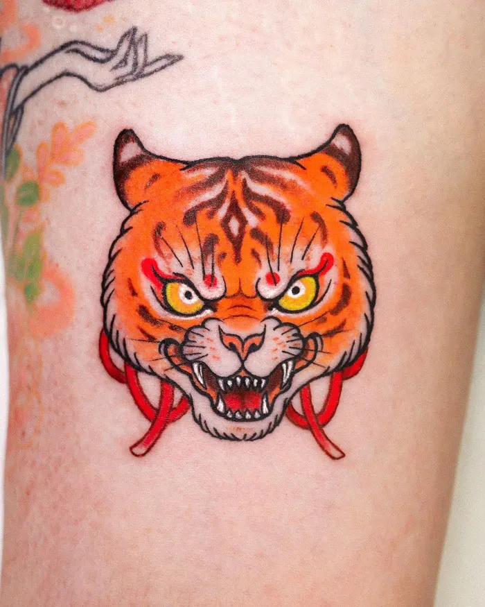 Tiger tattoo showcasing vibrant colors and fierce expression, celebrating the animal kingdom.